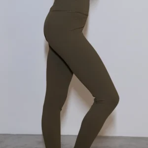 Giovane modella indossa leggings per Pilates Essential, color verde oliva, della linea di abbigliamento Be You Firenze