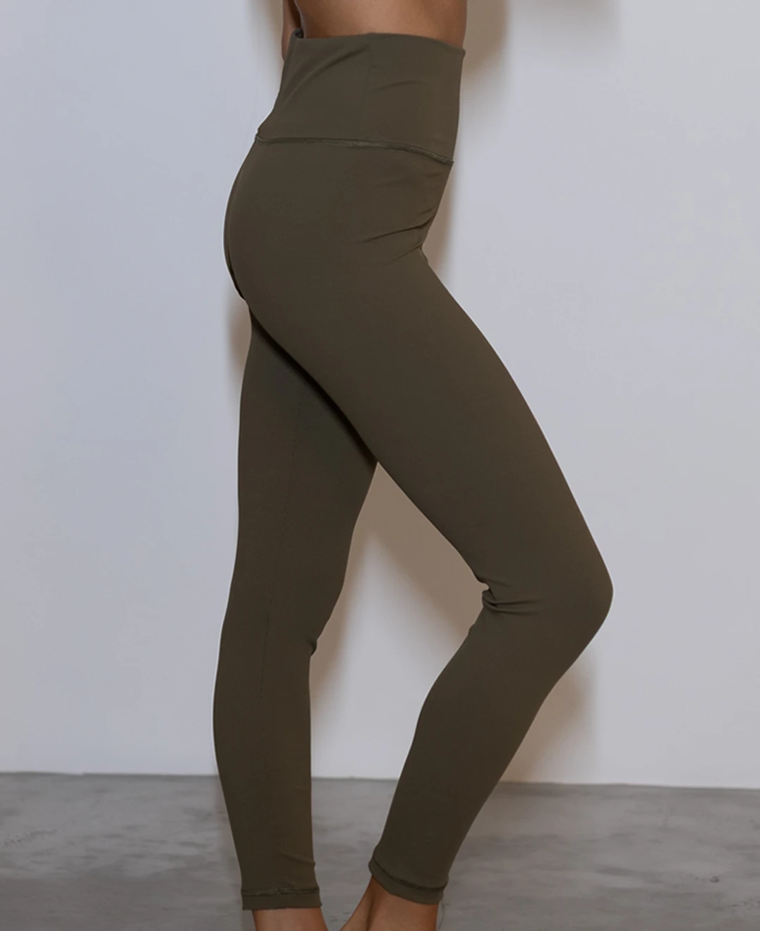 Giovane modella indossa leggings per Pilates Essential, color verde oliva, della linea di abbigliamento Be You Firenze