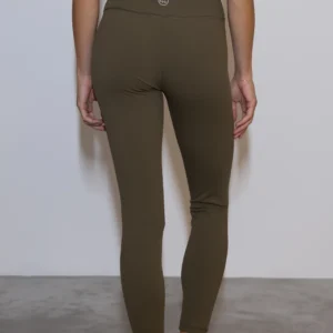 Giovane modella di spalle indossa leggings per Pilates Essential, color verde oliva, della linea di abbigliamento Be You Firenze