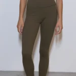 Giovane modella indossa leggings per Pilates, modello Essential, color verde oliva, della linea di abbigliamento Be You Firenze