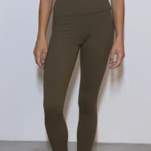 Giovane modella indossa leggings per Pilates, modello Essential, color verde oliva, della linea di abbigliamento Be You Firenze