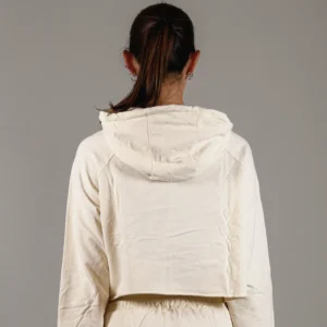 Giovane modella di spalle indossa felpa Crop con cappuccio per Pilates, color burro, modello Akira, della linea di abbigliamento Be You