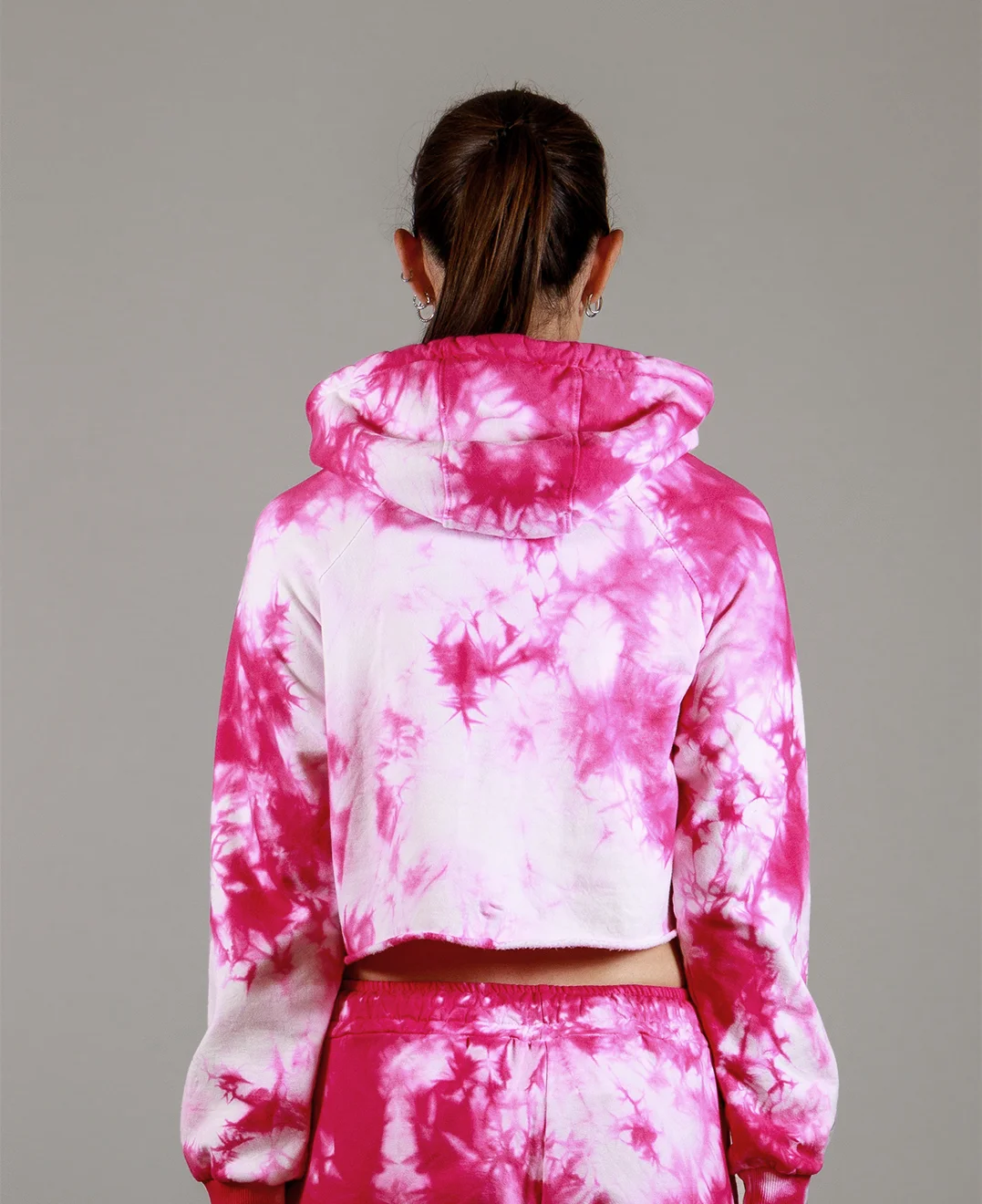 Giovane modella di spalle indossa felpa Crop con cappuccio per Pilates, fucsia Tie-Dye, modello Akira, della linea di abbigliamento Be You Firenze