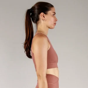 Giovane modella indossa top per Pilates Infinity, color cipria chic, della linea di abbigliamento Be You Firenze