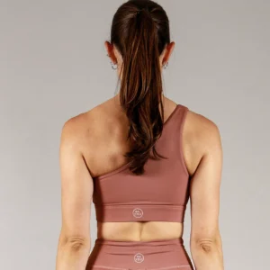 Giovane modella indossa top per Pilates Infinity, color cipria chic, della linea di abbigliamento Be You Firenze