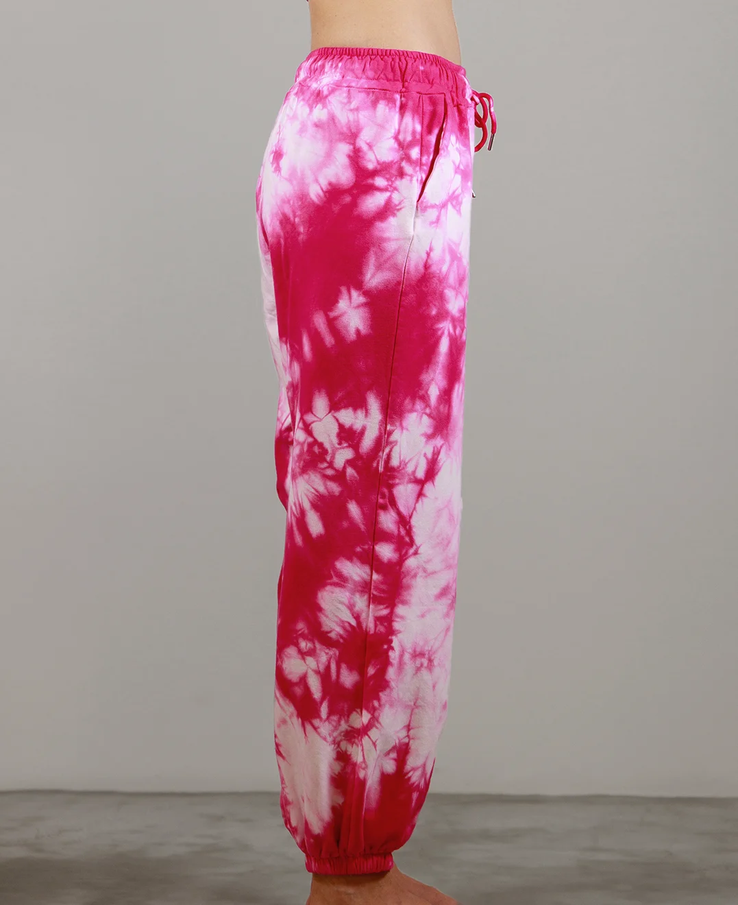 Giovane modella indossa pantalone tuta per Pilates, fucsia Tie-Dye, modello Akira, della linea di abbigliamento Be You Firenze