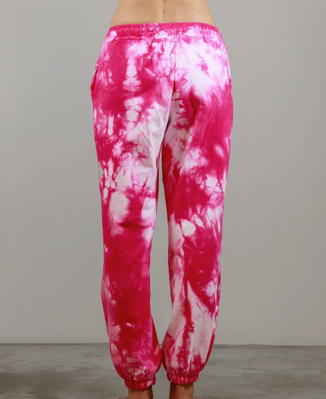 Giovane modella indossa pantalone tuta per Pilates, fucsia Tie-Dye, modello Akira, della linea di abbigliamento Be You Firenze