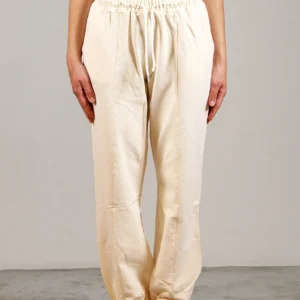 Giovane modella indossa pantalone tuta per Pilates, color burro, modello Akira, della linea di abbigliamento Be You Firenze