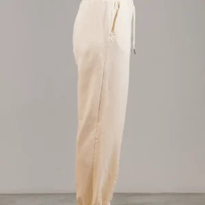 Giovane modella indossa pantalone tuta per Pilates, color burro, modello Akira, della linea di abbigliamento Be You Firenze