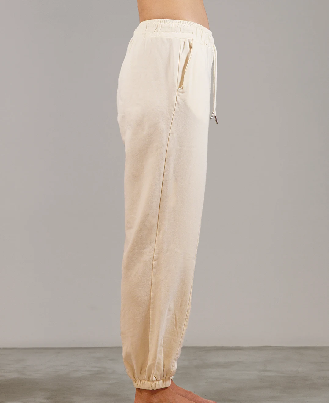 Giovane modella indossa pantalone tuta per Pilates, color burro, modello Akira, della linea di abbigliamento Be You Firenze