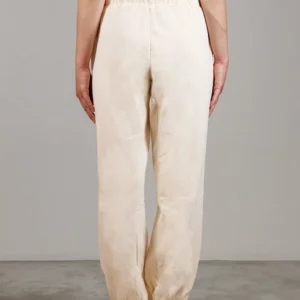 Giovane modella indossa pantalone tuta per Pilates, color burro, modello Akira, della linea di abbigliamento Be You Firenze